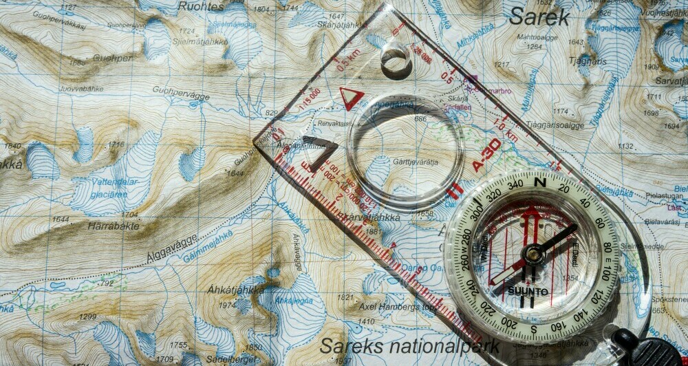 A compass overlaid on a map showing Sareks national park, Sweden