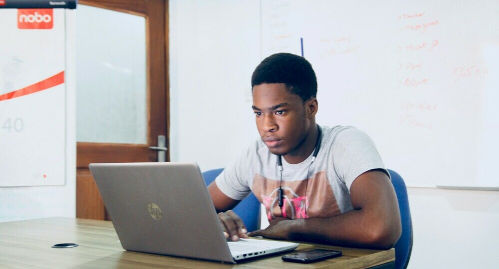 A man studying on his laptop. He is totally focussed.