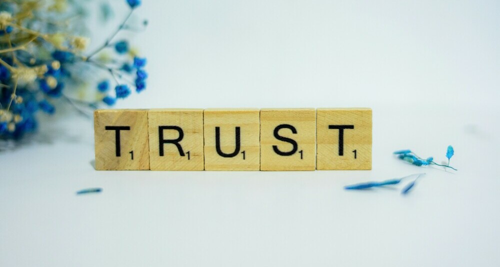 The word trust spelt out in Scrabble tiles