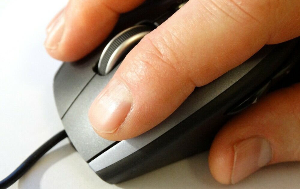 a hand on a computer mouse making a click